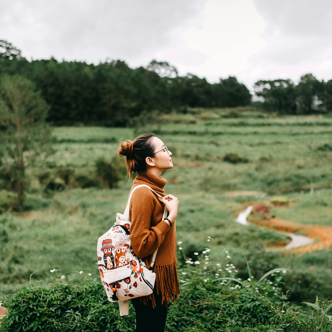 woman standing in the middle of grass field