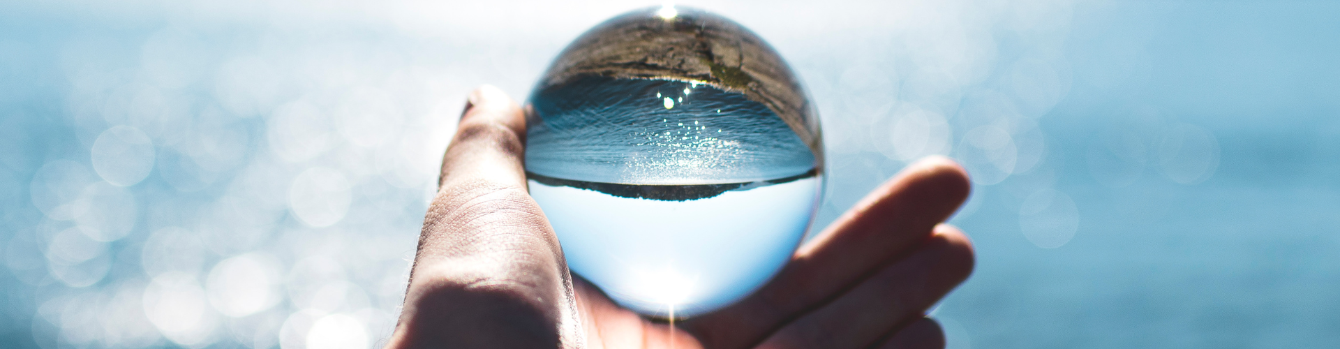 Bokeh Photography of Person Holding Water Drop